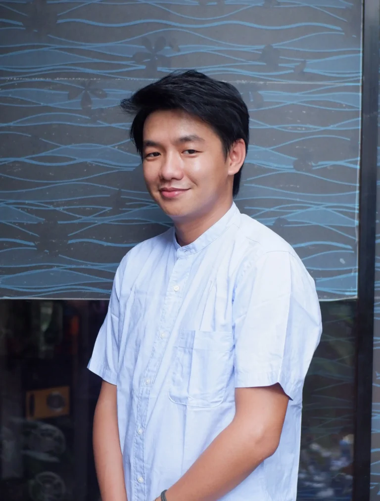 Jeff, web and graphic designer at Bloom Digital Marketing, standing against a patterned blue wall