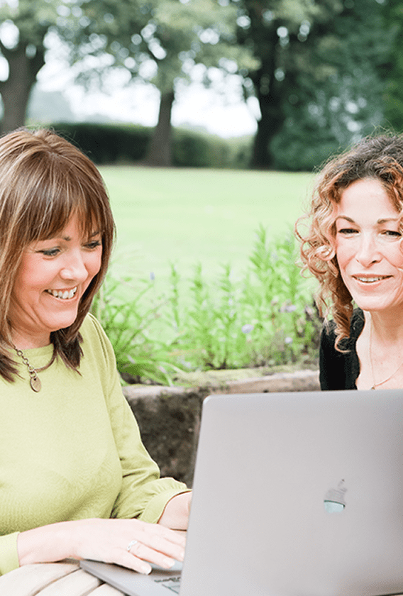 Jeanette Elton meeting clients and working at a desktop computer during the web design process