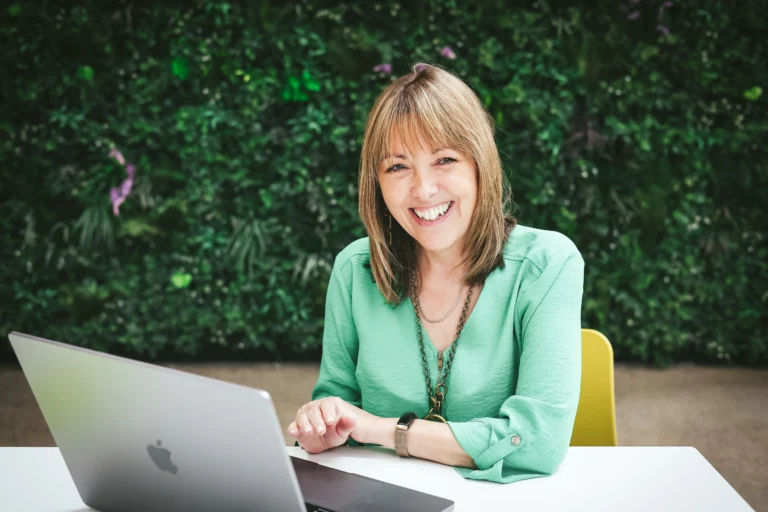 Jeanette Elton from Bloom Digital Marketing working on a laptop at an outdoor table